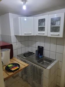 a kitchen with white cabinets and a sink and a stove at STUDIO TI COIN SYMPA en plein centre ville in Saint-Laurent du Maroni