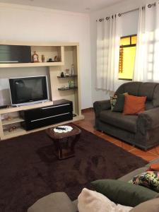 sala de estar con sofá y TV en Chácara Recanto do Berzelai en Bueno Brandão