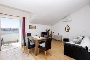 ein Wohnzimmer mit einem Tisch und einem Sofa in der Unterkunft Apartments by the sea Brodarica, Sibenik - 466 in Brodarica