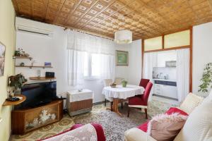 ein Wohnzimmer mit einem Tisch und einem TV in der Unterkunft Apartments by the sea Brodarica, Sibenik - 466 in Brodarica