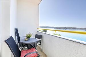 einen Balkon mit einem Tisch und Stühlen sowie Meerblick in der Unterkunft Apartments by the sea Brodarica, Sibenik - 466 in Brodarica