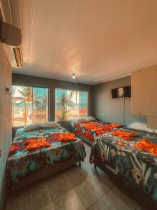 a bedroom with two beds and a large window at Pousada França in Japaratinga