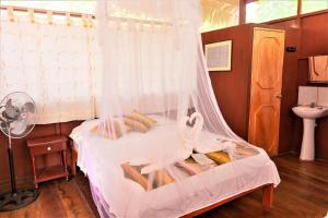Santa TeresaAvatar Amazon Lodge & Canopy Park的带床和蚊帐的卧室