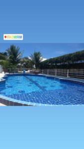 ein großer Pool in einem Resort mit Palmen in der Unterkunft Pousada e Hostel clubhouse in Camassari