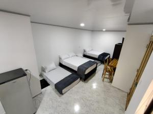 Habitación con 2 camas y TV. en Apartahotel Sevilla, en Medellín