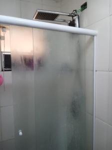 eine Duschtür im Bad mit Waschbecken in der Unterkunft Casa linda Praia dos Sonhos in Itanhaém