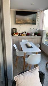 - une table et des chaises blanches dans la cuisine dans l'établissement Hermoso y comodo Departamento con vista al mar, costas de montemar, à Concón