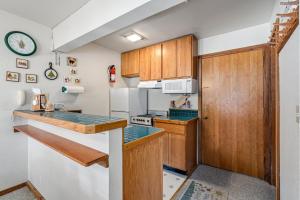 a kitchen with wooden cabinets and a counter top at Cozy & Bright Condo - Tamarack 18 home in Tamarack