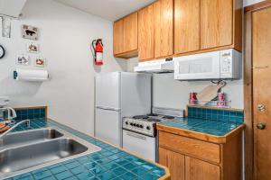 a kitchen with a sink and a white refrigerator at Cozy & Bright Condo - Tamarack 18 home in Tamarack