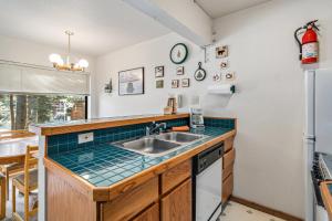 a kitchen with a sink and a refrigerator at Cozy & Bright Condo - Tamarack 18 home in Tamarack