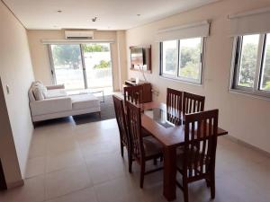 uma sala de estar com uma mesa, cadeiras e um sofá em Edificio Carmelitas insuperable una habitación em Assunção