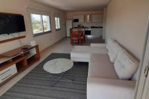 a living room with a white couch and a table at Edificio Carmelitas insuperable una habitación in Asuncion