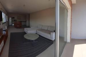 uma sala de estar com um sofá branco e uma mesa em Edificio Carmelitas insuperable una habitación em Assunção mais 1 fotografia