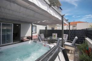 een hot tub op een patio met een tafel en stoelen bij Apartments with a parking space Trogir - 22015 in Trogir