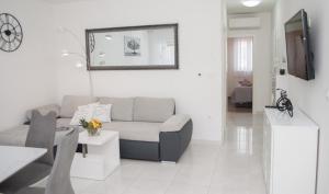 een woonkamer met een bank en een tv bij Apartments with a parking space Trogir - 22015 in Trogir