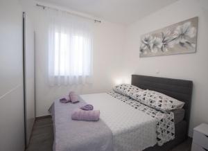 een slaapkamer met een bed met twee handdoeken erop bij Apartments with a parking space Trogir - 22015 in Trogir