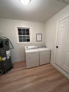 a laundry room with a washing machine and a window at Beautiful Home. W/Hot Tub. Great Location in Taylors