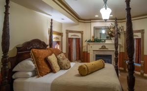 1 dormitorio con cama con almohadas y chimenea en The Anniversary Inn - Logan en Logan