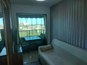 um quarto com um sofá, uma mesa e uma janela em Excelente apartamento 02 quartos frente ao mar em Salvador