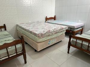 a room with two beds and two chairs in it at Casa Cantinho da Família - Praia de Guaibim - in Guaibim