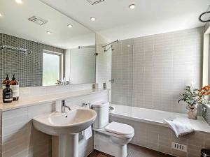a bathroom with a sink and a toilet and a tub at Villa Lago in Lovedale +10 photos