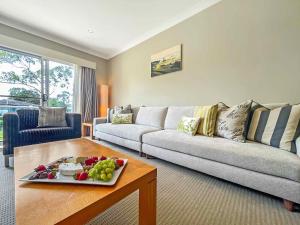 uma sala de estar com um sofá e uma mesa com uma bandeja de frutas em Villa Lago em Lovedale