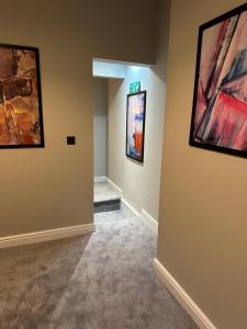 a hallway with paintings on the walls at City Centre Studios @44 by DH ApartHotels in Peterborough