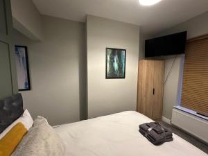 a bedroom with a bed with a bag on it at City Centre Studios @44 by DH ApartHotels in Peterborough