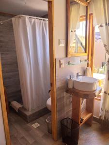 y baño con lavabo y ducha. en Casa Ñawi en San Pedro de Atacama