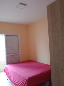 - une chambre avec un lit rose dans l'établissement Apartamento novo Vila Guilhermina, à Praia Grande