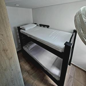 卡塔赫納的住宿－Cómodo apartamento en Cartagena，配有风扇的客房内的一张黑色双层床