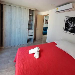卡塔赫納的住宿－Cómodo apartamento en Cartagena，一间卧室配有红色的床和红色毯子