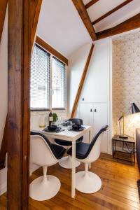 a dining room with a white table and chairs at Comfy studio lumineux - Trocadero Doumer 2 in Paris