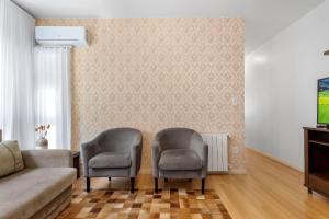 a living room with two chairs and a couch at Morada da Montanha 2 dorm by Achei Gramado in Gramado