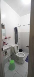 a white bathroom with a toilet and a sink at 3-Bedroom House in Butuan
