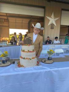 Ein Mann mit einem Cowboyhut schneidet einen Kuchen in der Unterkunft Luxurious farm house! 5-bed, 4 bath, pool and spa. in Bonham + 34 Fotos