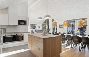 a kitchen with white cabinets and a table with chairs at Aqua 242 in Charlottenthal