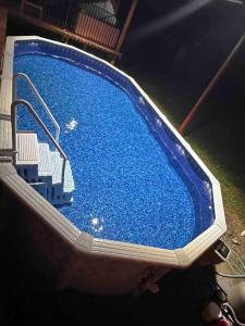 ein großer blauer Pool mit einem Stuhl darin in der Unterkunft Luxurious farm house! 5-bed, 4 bath, pool and spa. in Bonham