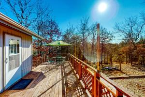 a wooden deck with a table and an umbrella at The Cove in Golden