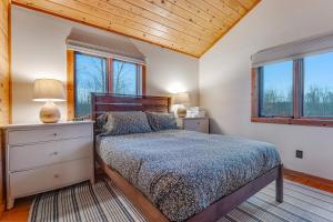 um quarto com uma cama e duas janelas em Sunset Hideaway, Main House em Isle la Motte