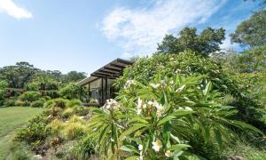 a house in a garden with plants at Lily Pad at Byron Bay in Byron Bay