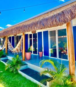 a villa with a hammock and a resort at Noah Hostel & Chale in São Miguel do Gostoso
