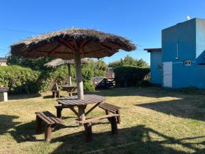 una mesa de picnic y una sombrilla en un patio en Ayres de Cobo en Mar de Cobo