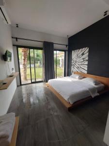 ein Schlafzimmer mit einem großen Bett und einem großen Fenster in der Unterkunft Mercusuar Resort Jepara in Kesembu