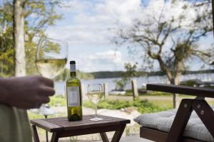 una bottiglia di vino e un bicchiere su un tavolo di Toftastrand Hotell a Växjö