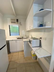 cocina con armarios blancos y microondas en COST EFFECTIVE ISLAND ESCAPE! Studio Unit, Nelly Bay en Nelly Bay