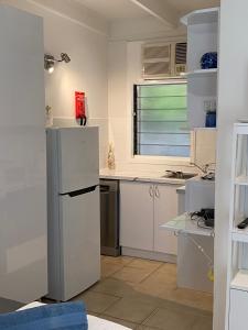 cocina con nevera y ventana en COST EFFECTIVE ISLAND ESCAPE! Studio Unit, Nelly Bay en Nelly Bay