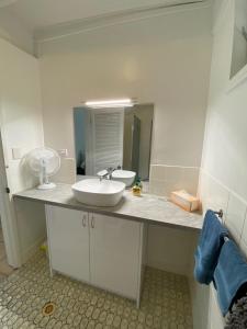 ein Bad mit einem Waschbecken und einem Spiegel in der Unterkunft COST EFFECTIVE ISLAND ESCAPE! Studio Unit, Nelly Bay in Nelly Bay