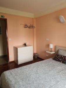 a bedroom with a bed and a dresser and a lamp at Hospedagem Emanuel in Caneças