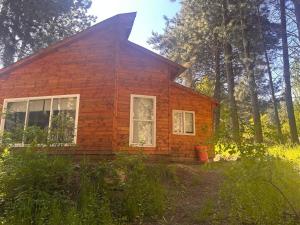 una pequeña casa de ladrillo rojo en el bosque en Cabañas Altos del Simpson, en Coyhaique